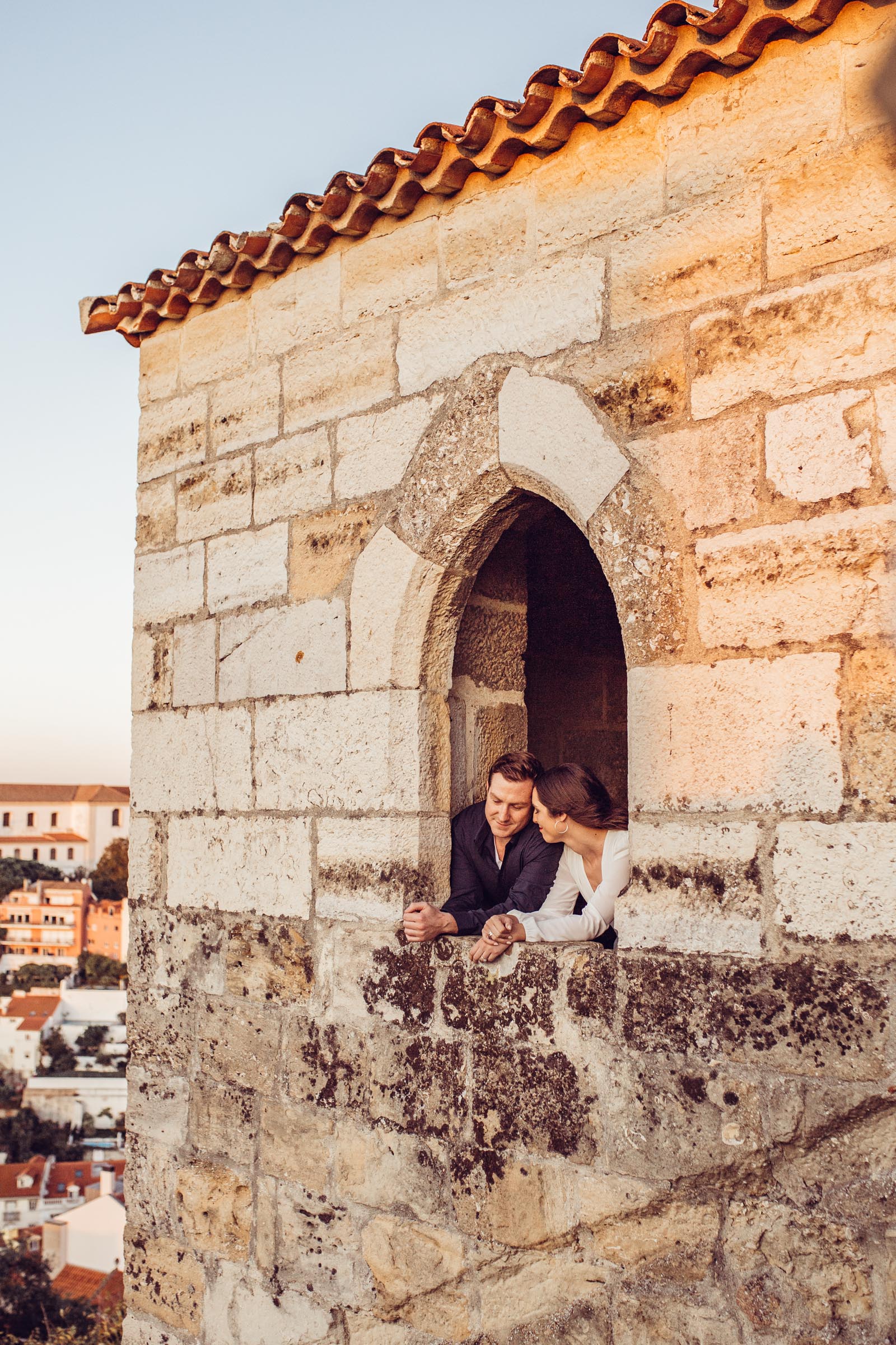 Couple kisses in castle window in Lisbon Portugal