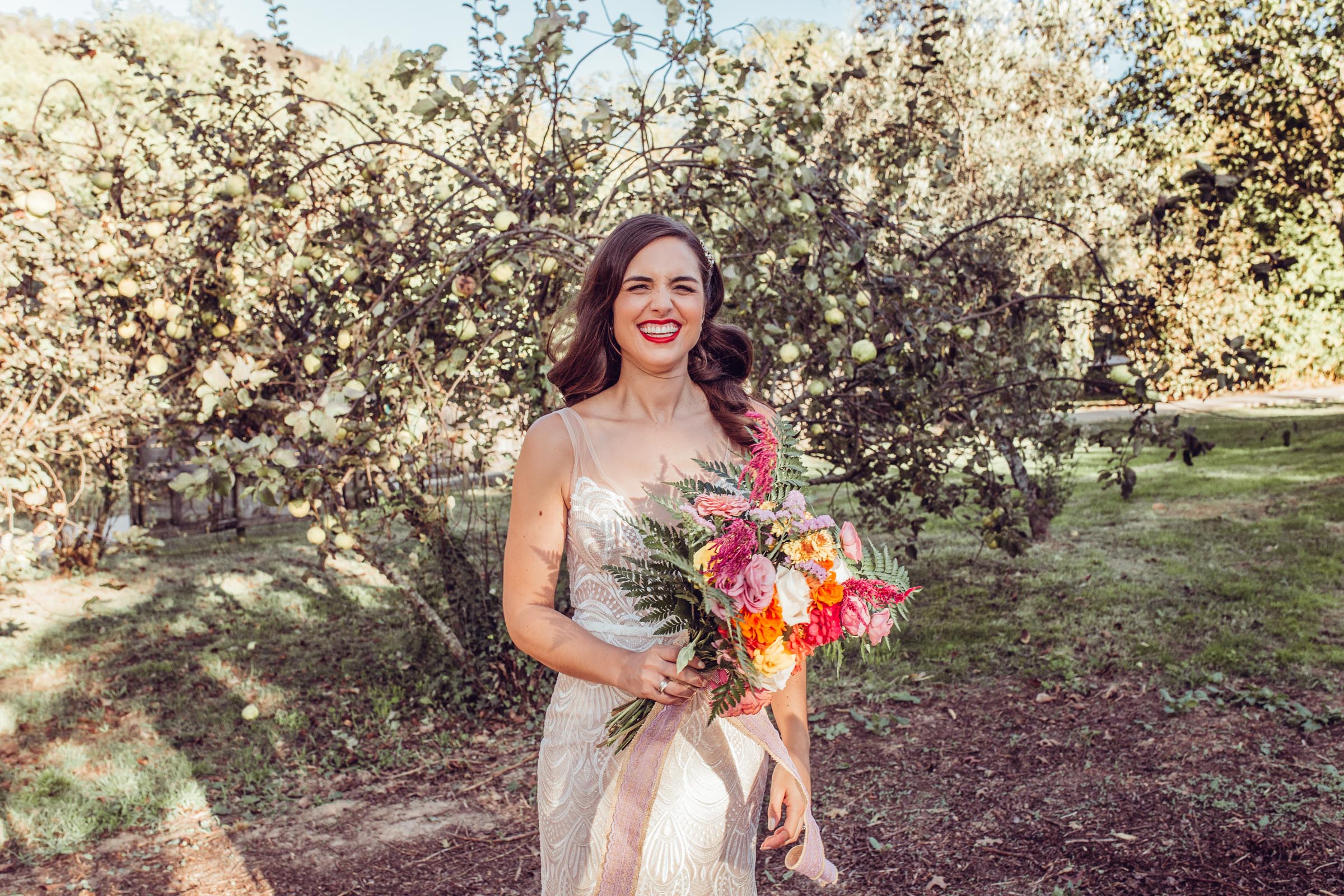 Bride smiles in front of olive trees at wedding Herdade da Matinha portugal
