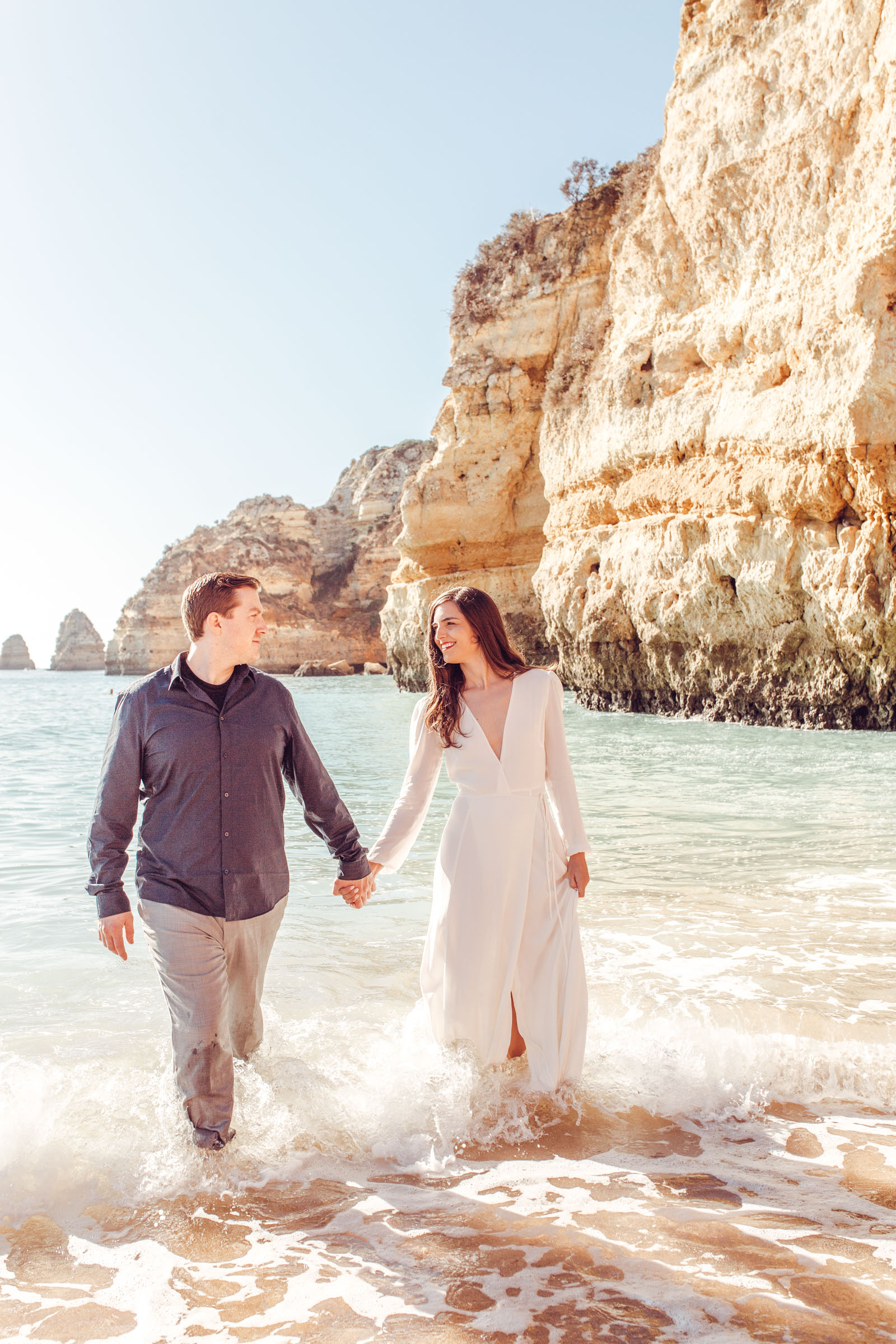 Couple dances in waves at beach in lagos portugal