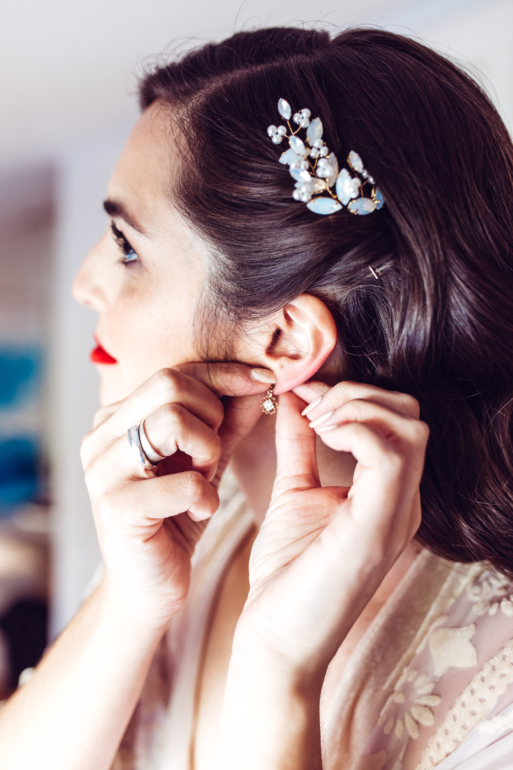 Bride puts on earings morning of her wedding in Portugal