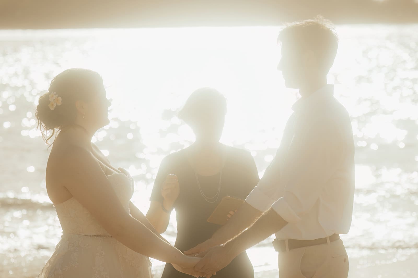 Kauai hawaii Elopement couple holds hands during vows on tunnels beach