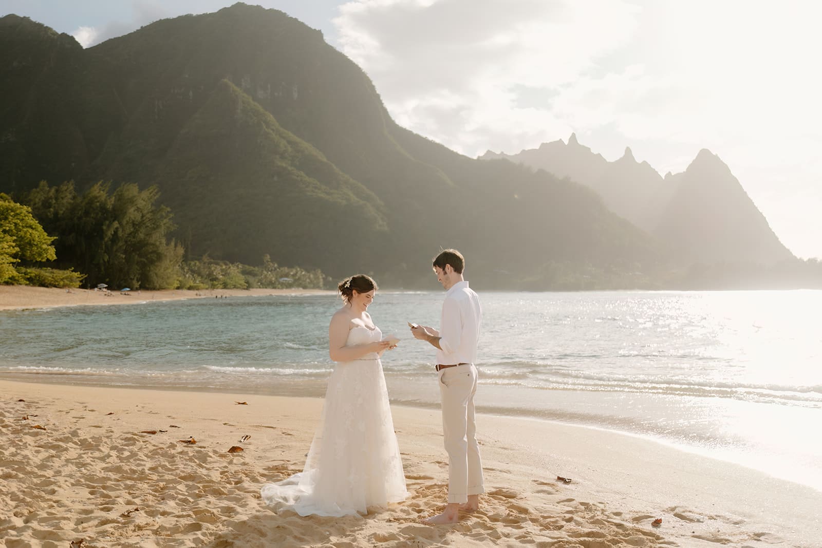 bride and groom read vows on tunnel's beach in kauai hawaii